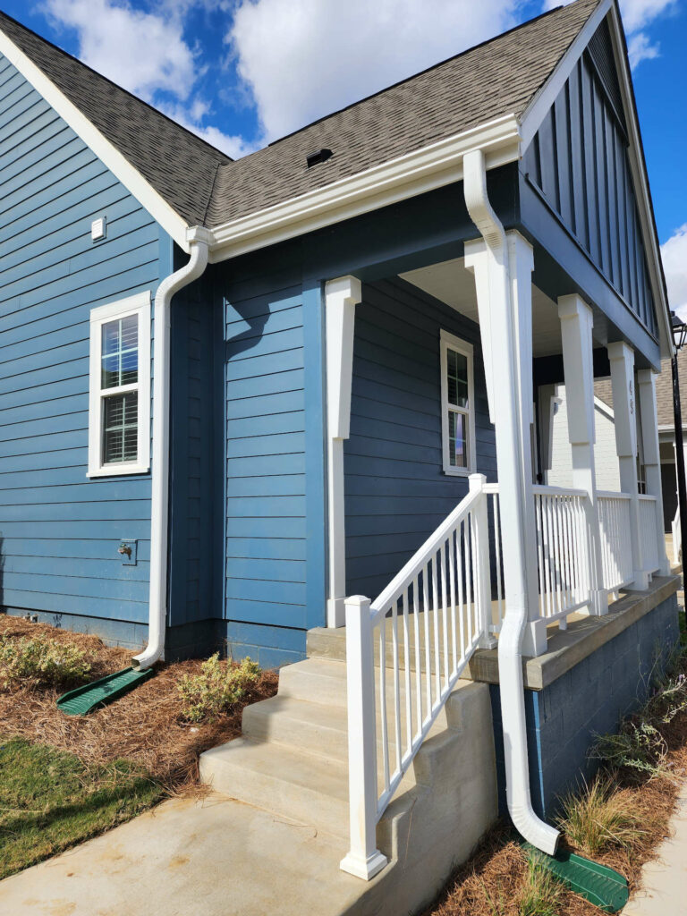 White seamless gutters on a blue-sided home