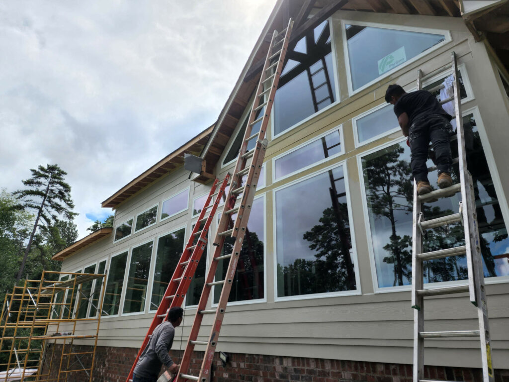 Men working on ladders outside house