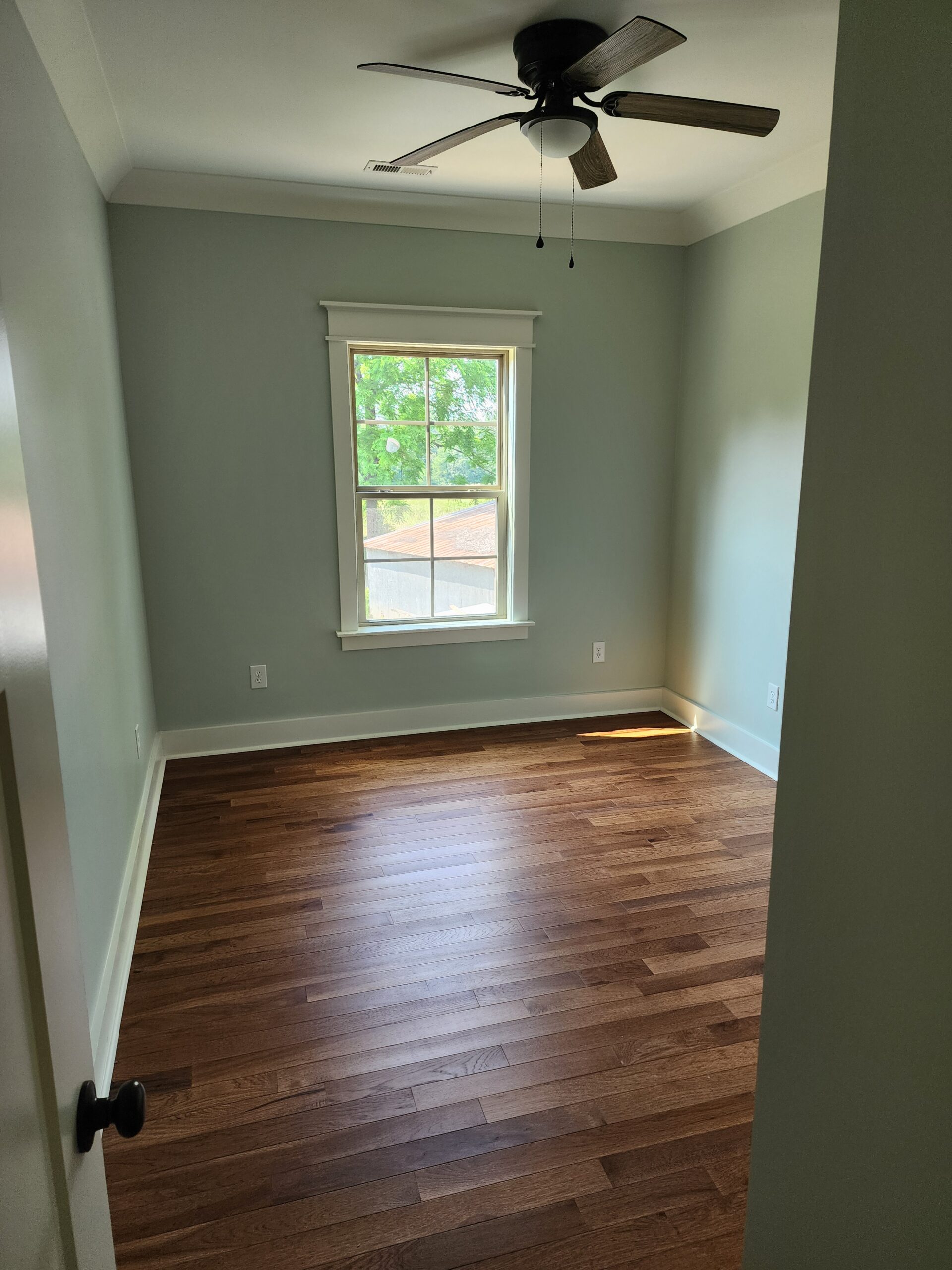 Newly finished interior room with hardwood floors and freshly painted walls