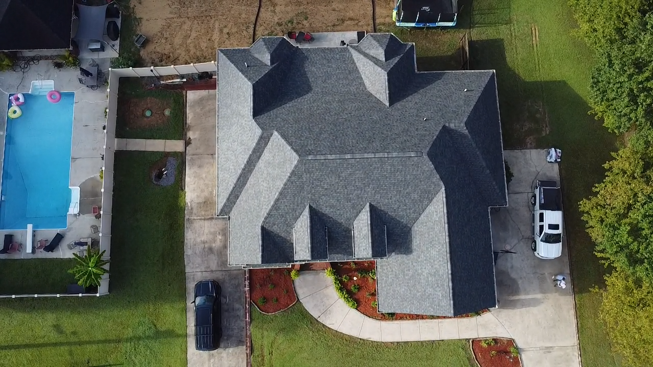 New roof on large house from above with yard and pool