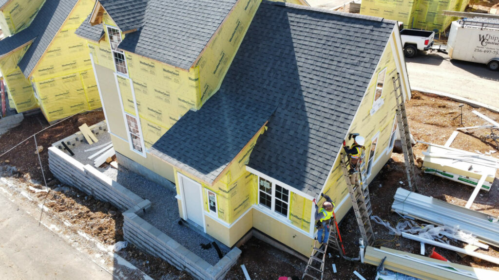 Men working on ladders working on house