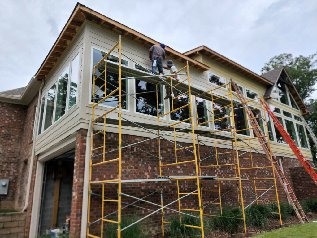 Men on scaffolding outside house
