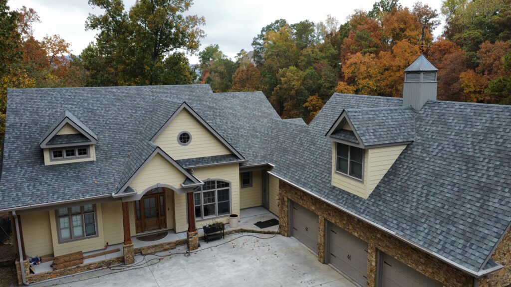 Overhead view of new roof on large house with concrete driveway
