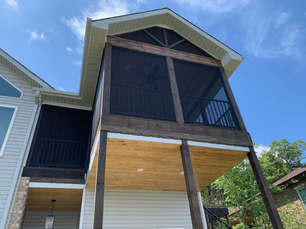 2nd-story screened in porch with blue sky and trees in the background